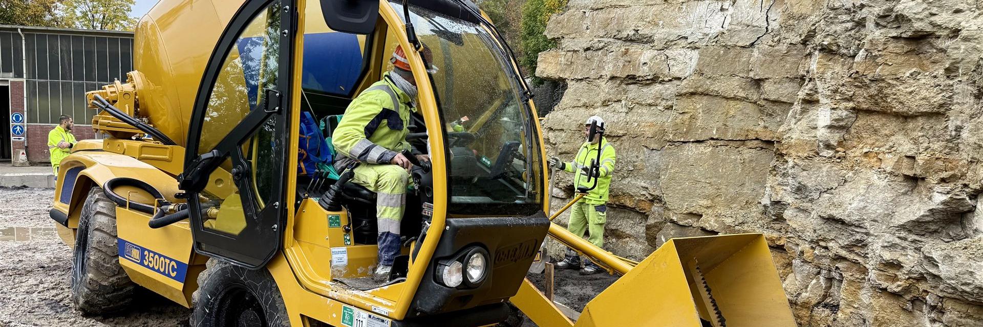 selbstladender Betonfahrmischer CARMIX 3500TC füllt Beton in eine Schalung nahe am Fels
